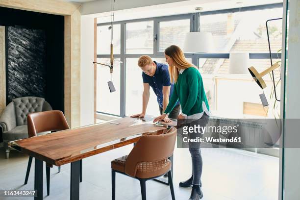 couple shopping for new furniture in showroom - buying furniture stock pictures, royalty-free photos & images