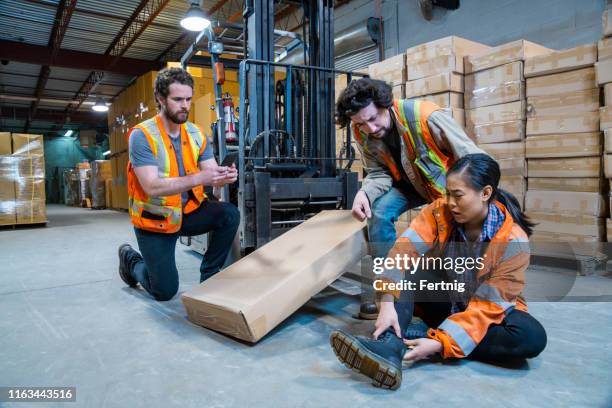 un argomento sulla sicurezza sul posto di lavoro del magazzino industriale. un operaio è rimasto ferito cadendo o colpito da un carrello elevatore. - forklift accident foto e immagini stock