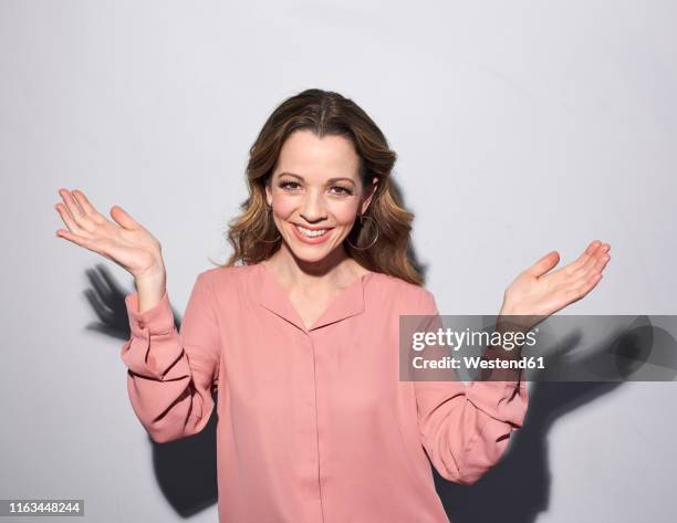 portrait of happy brunette woman raising her arms - pink blouse foto e immagini stock