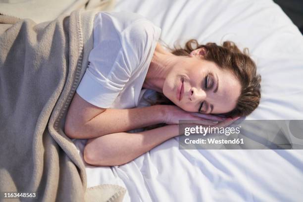 content woman sleeping in bed - sleeping woman stock-fotos und bilder