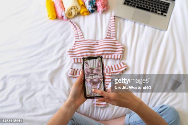 woman taking smartphone picture of bikini on bed - klädesplagg bildbanksfoton och bilder