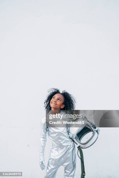 portrait of smiling little girl wearing space suit in front of white background looking up - astronaut kid stockfoto's en -beelden