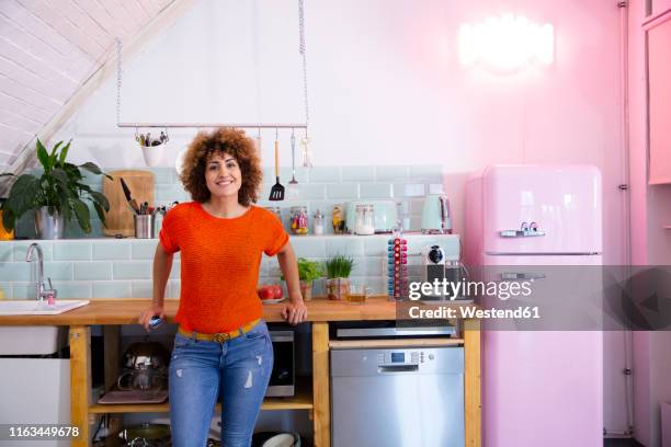 portrait of smiling woman standing in office kitchen - refrigerator front stock pictures, royalty-free photos & images