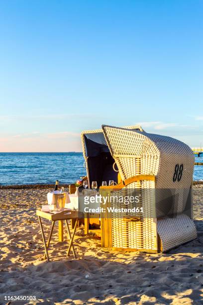 laid table and hooded beach chairs at the beach in the evening, heiligendamm, germany - hooded beach chair stock pictures, royalty-free photos & images