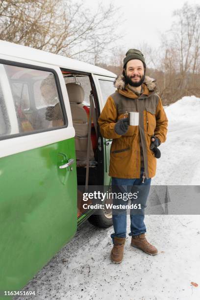 portrait of smiling man with electric van in winter landscape, kuopio, finland - mid volwassen mannen stockfoto's en -beelden