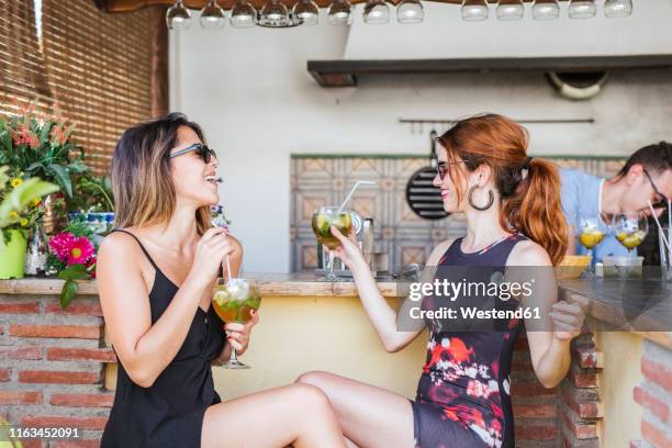 two women having a drink at a bar - bar outside stock-fotos und bilder