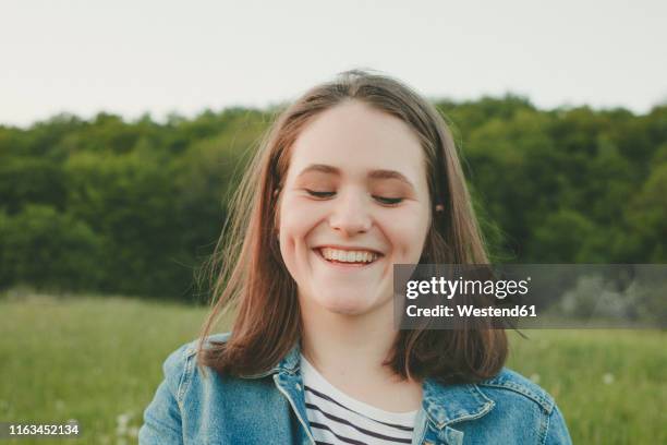 portrait of laughing teenage girl in nature - grübchen stock-fotos und bilder