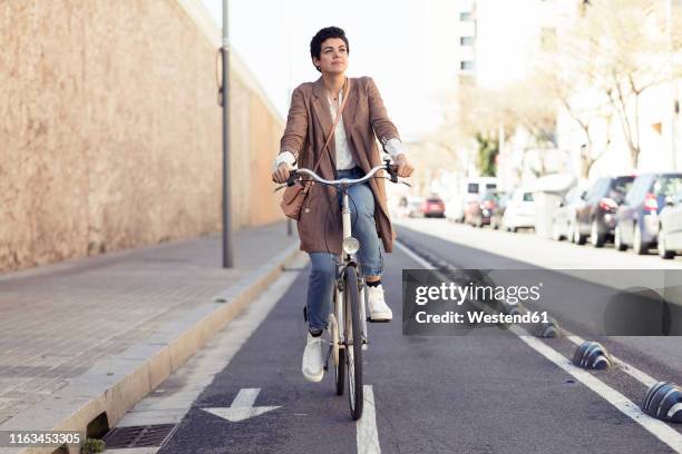 woman with bike on bicycle lane in the city - pista ciclabile foto e immagini stock