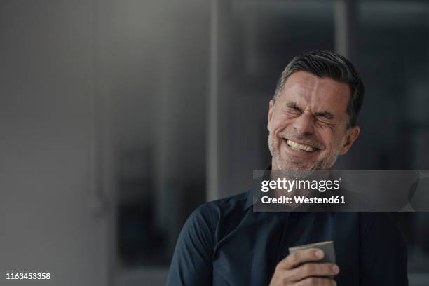 happy mature businessman holding a cup - man laughing photos et images de collection