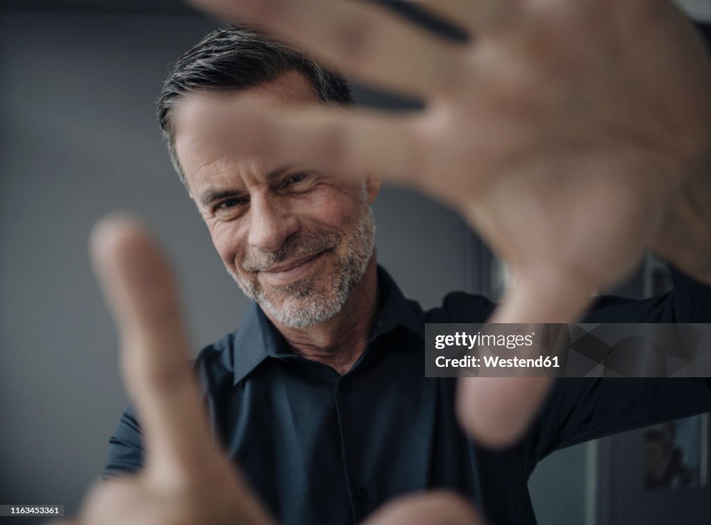 Portrait of smiling mature businessman making a finger frame