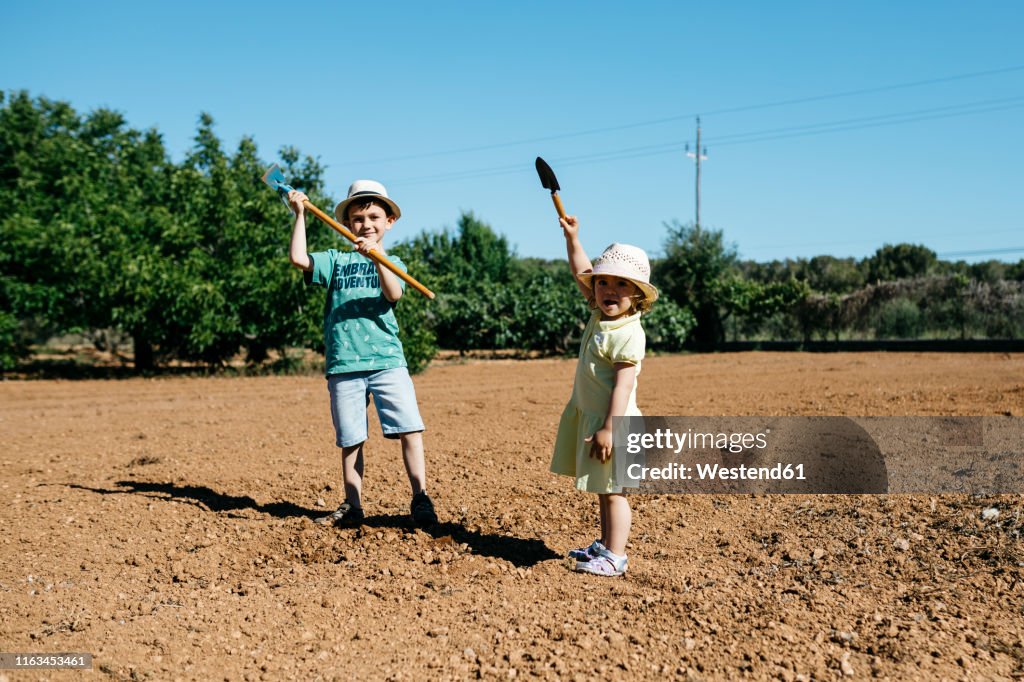 Boy and girl plowing the ground