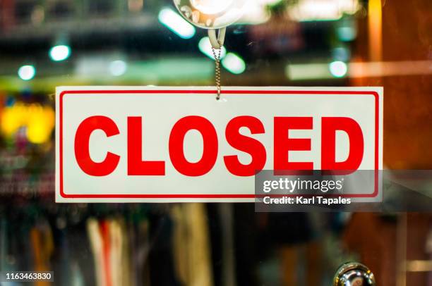 a glass door with "closed" store sign - store sign stock-fotos und bilder