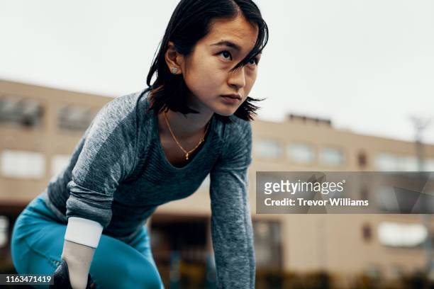 female adaptive athlete training for competition at a university athletics stadium - posizione sportiva foto e immagini stock