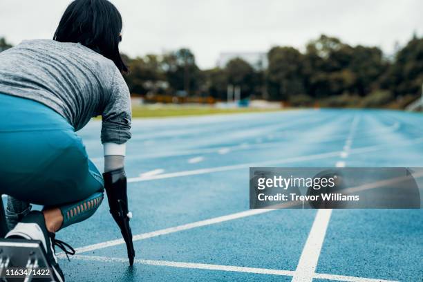 Female adaptive athlete training for competition at a university athletics stadium