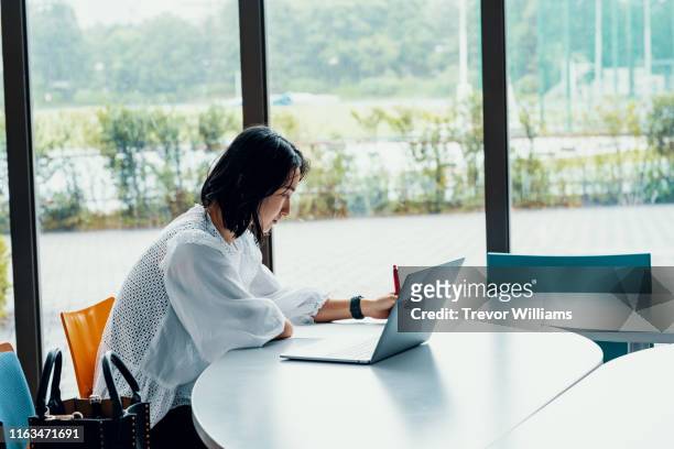 female student with an amputated arm at a university campus - japanese woman stock pictures, royalty-free photos & images