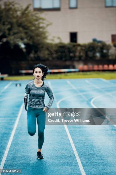 Female adaptive athlete training at a running track