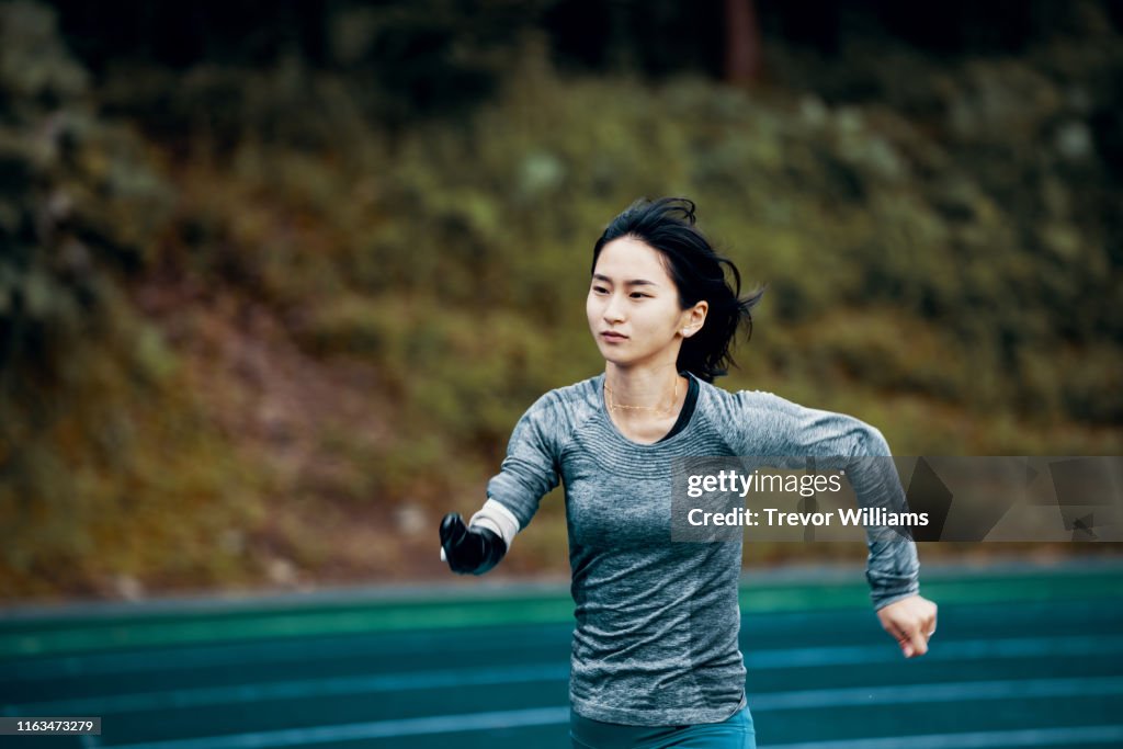 Female adaptive athlete training at a running track