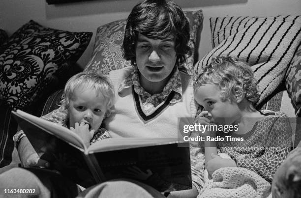 Comedian and actor Michael Palin reading a story to his children William and Thomas, September 1973.