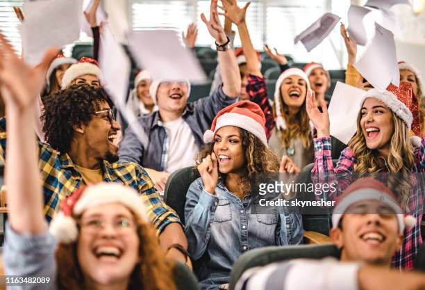 grote groep vrolijke studenten die nieuwjaar vieren in de collegezaal. - season finale stockfoto's en -beelden