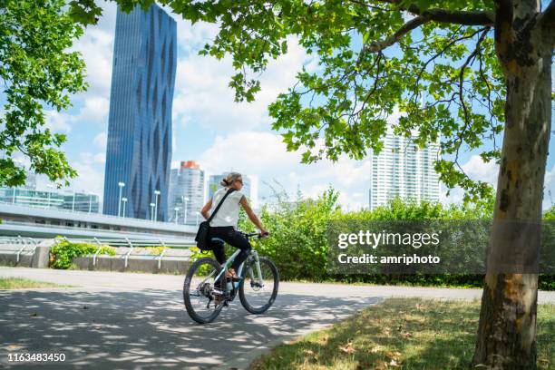 geschäftsfrau im stadtpark unterwegs - fahrradweg stock-fotos und bilder