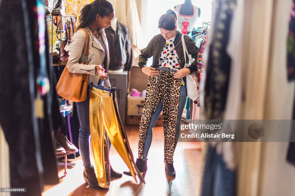 Two young women looking at clothes in a vintage clothes shop