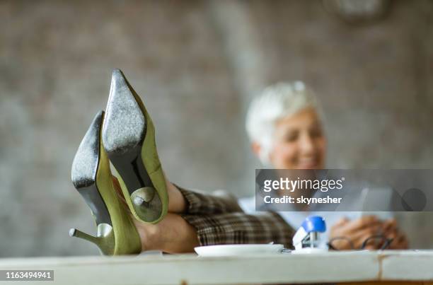 close-up van zakenvrouw voeten in hoge hakken op tafel. - high heels photos stockfoto's en -beelden