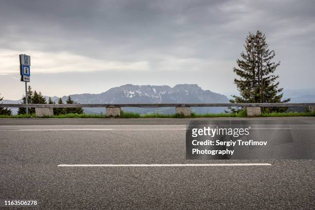 empty road on mountain pass side view - street stock-fotos und bilder