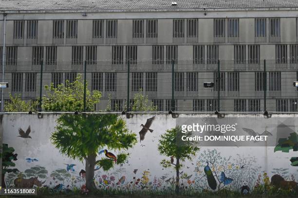 Picture shows a mural in the walking yard of the Poissy prison, specialised in long sentences, August 14 in Poissy, west of Paris. - Behind the high...