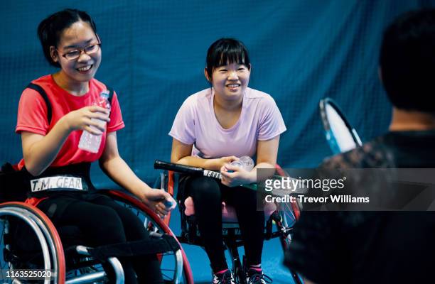 Teenage girls taking a break from playing wheelchair tennis
