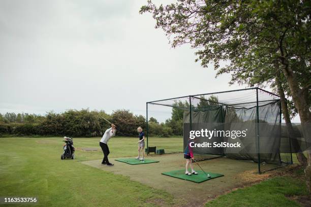 practicing her golf on the driving range - driving range stock pictures, royalty-free photos & images