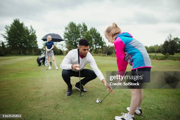 pro golfer aids younger girl golfer - drill stock pictures, royalty-free photos & images