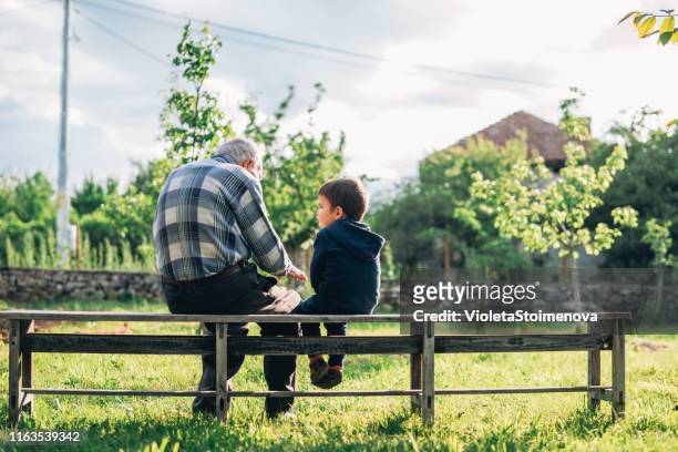 nonno e nipote all'aperto. - children sitting back foto e immagini stock