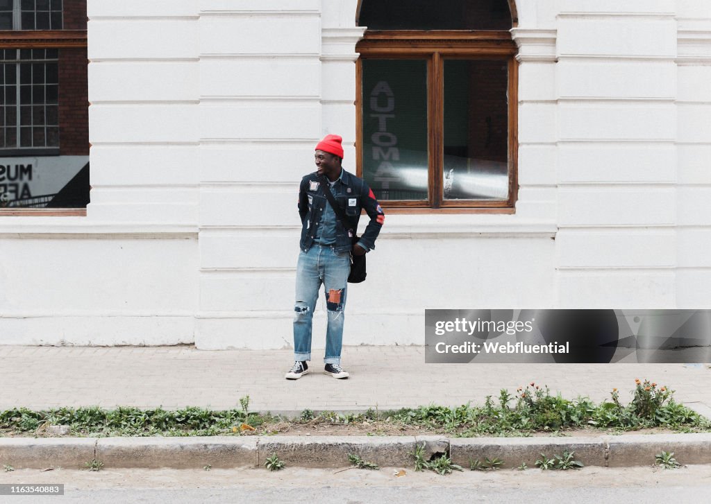 Young African man wearing a red hat and denim jacket and hat outdoors