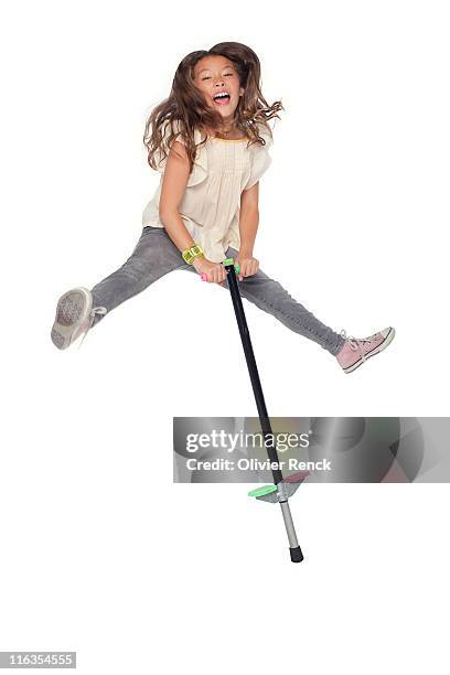 a young girl jumping on a pogo stick. - pogo stock-fotos und bilder