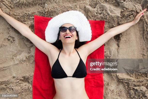frau ist sonnenbaden am strand - woman towel beach stock-fotos und bilder