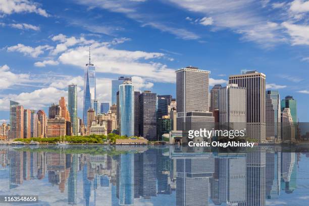 new york city skyline with manhattan financial district and world trade center reflected in water of new york harbor, ny, usa. - skyline stock pictures, royalty-free photos & images