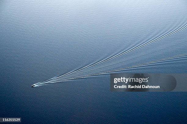 an aerial view of a boat leaving ripples in lake tahoe creating an abstract pattern, ca. - wake boat stock pictures, royalty-free photos & images