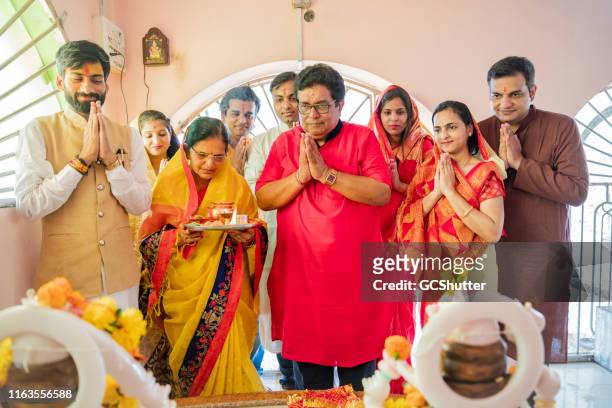 multi generation family attending prayers at a hindu temple - diwali family stock pictures, royalty-free photos & images
