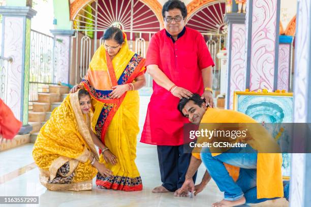 young couple taking blessings from their parents at a hindu temple - mom blessing son stock pictures, royalty-free photos & images