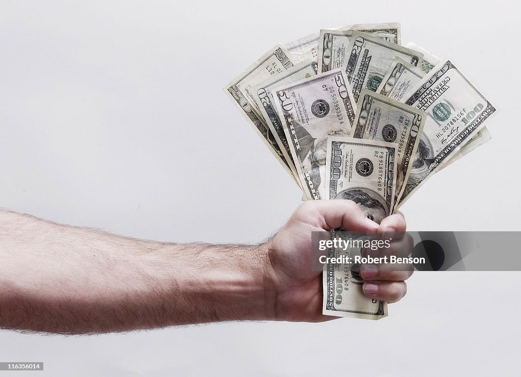 Man holds fist of dollars