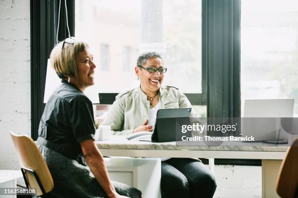 laughing mature female business partners in meeting in office - fun experience stock pictures, royalty-free photos & images