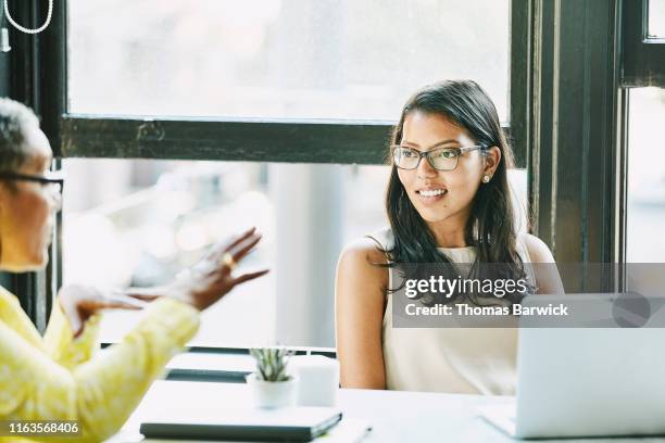 Businesswoman listening to ideas from colleague during meeting in office
