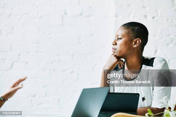 businesswoman listening to client during meeting in office conference room - patience office stock pictures, royalty-free photos & images
