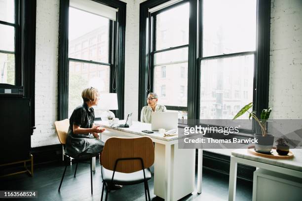 mature businesswoman meeting with client in office - customer service representative stock-fotos und bilder