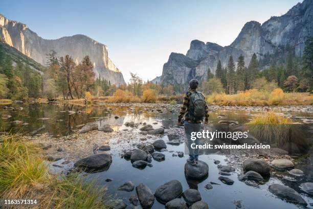 jonge man overweegt yosemite valley vanaf de rivier, reflecties op het wateroppervlak - el capitan yosemite national park stockfoto's en -beelden