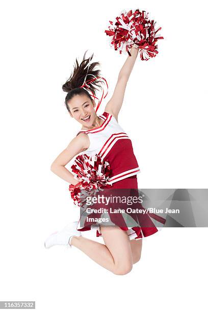 cheerleader in action with her pom-poms - asian cheerleaders stock-fotos und bilder