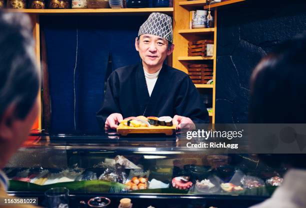 japanse sushi-chef in een sushi-winkel - sushi restaurant stockfoto's en -beelden