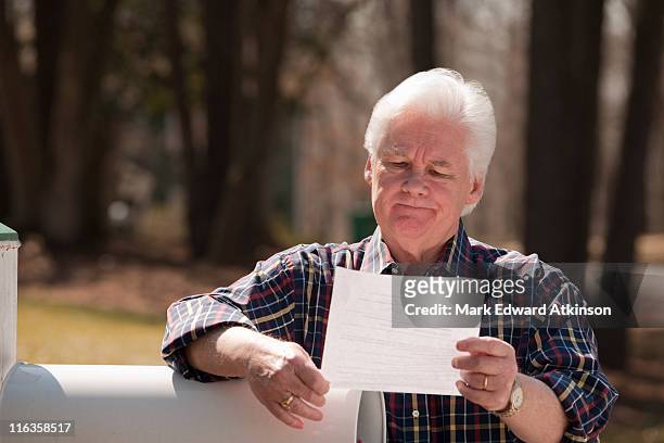 usa, virginia, richmond, senior man reading letter by mailbox - reading letter stock pictures, royalty-free photos & images