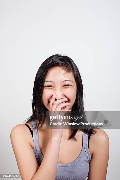 usa, new york city, young woman covering mouth when laughing - hair parting stockfoto's en -beelden
