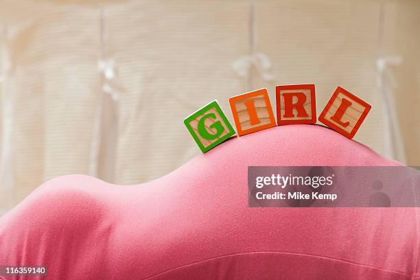 usa, utah, lehi, wooden blocks with letters on pregnant woman's belly, reading as girl - it's a girl stock-fotos und bilder